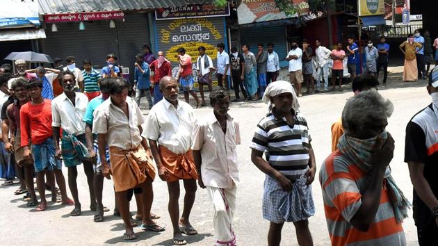 People stand in a queue as they wait for their turn to get the food packet which is being distributed by volunteers during the lockdown in Kochi on Tuesday. (ANI Photo) People stand in a queue as they wait for their turn to get the food packet which is being distributed by volunteers during the lockdown in Kochi on Tuesday. (ANI Photo)