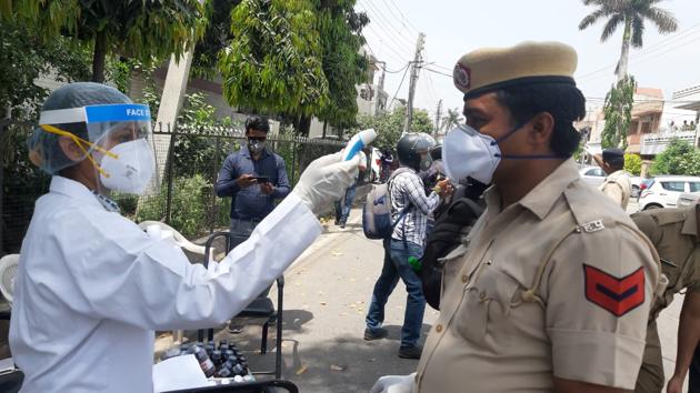 A health department official screens a police officer at Sector 15 in Panchkula on Wednesday. (Sant Arora/HT) A health department official screens a police officer at Sector 15 in Panchkula on Wednesday. (Sant Arora/HT)