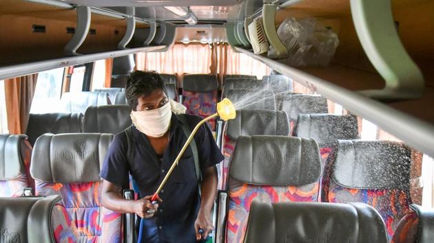 A cleaning staff member sprays disinfectant on a bus in wake of coronavirus pandemic at bus depot in Vijayawada.(ANI)