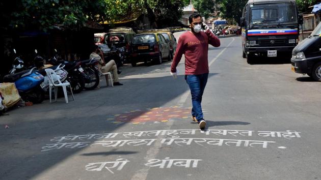 A man walking on the Covid-19 related graffiti created on the road. (Satish Bate/HT Photo) A man walking on the Covid-19 related graffiti created on the road. (Satish Bate/HT Photo)