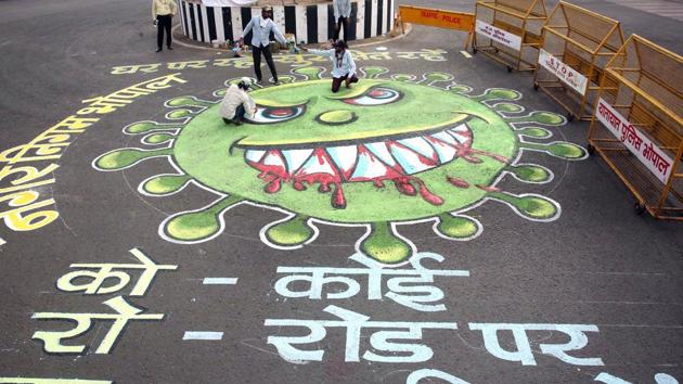 Artists paint a graffiti on a road to make people aware about the coronavirus during the second phase of nationwide Covid-19 lockdown in Guwahati on Wednesday. (ANI Photo)
