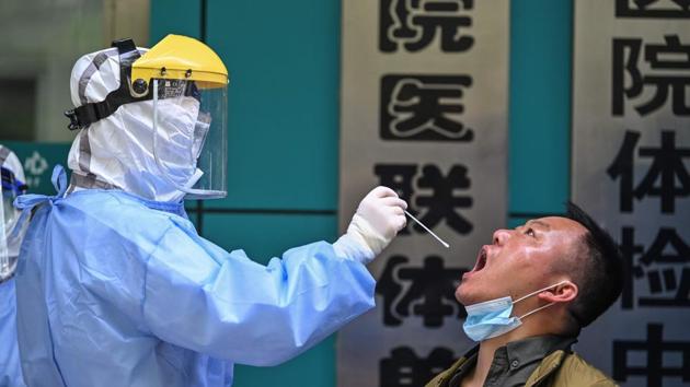 A medical worker takes a swab sample from a man being tested for Covid-19 in Wuhan, April 16. (AFP Photo) A medical worker takes a swab sample from a man being tested for Covid-19 in Wuhan, April 16. (AFP Photo)