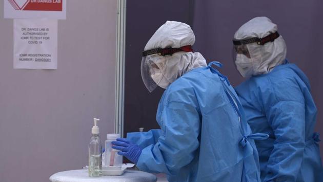 Medics in PPE kits during a demonstration on taking samples from Covid-19 suspected patients at a drive-through test facility.(Sanchit Khanna/HT PHOTO)