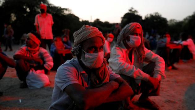 Daily wage workers and homeless people wearing protective masks wait on the banks of Yamuna river as police officers arrange buses to transfer them to a shelter, after India extended a nationwide lockdown to slow the spreading of the coronavirus disease.(Reuters photo)