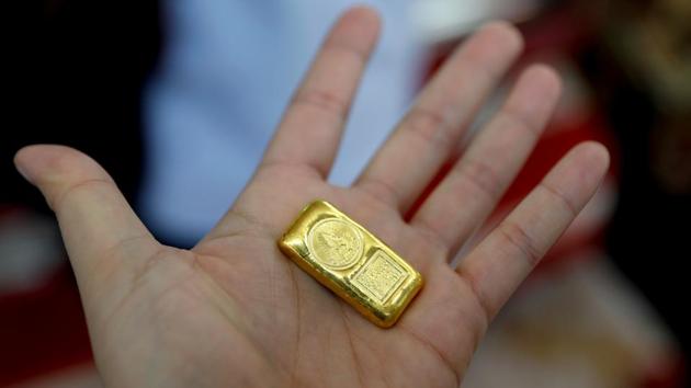 A customer shows a piece of gold for sell at a goldsmith, as the demand for cash increased after the partial shut down caused by the outbreak of the coronavirus disease (COVID-19), in Bangkok, Thailand. (REUTERS) A customer shows a piece of gold for sell at a goldsmith, as the demand for cash increased after the partial shut down caused by the outbreak of the coronavirus disease (COVID-19), in Bangkok, Thailand. (REUTERS)