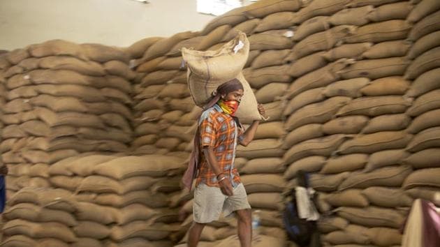 An Indian laborer carries a rice bag after they were unloaded from trains to store at a Food Corporation of India (FCI) warehouse during lockdown. (AP) An Indian laborer carries a rice bag after they were unloaded from trains to store at a Food Corporation of India (FCI) warehouse during lockdown. (AP)