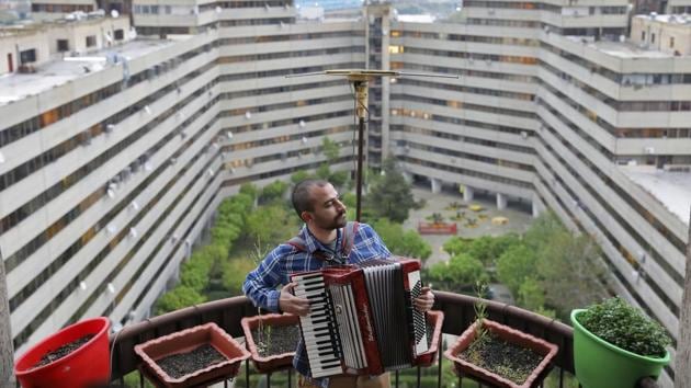 Behnam Emran, a 28 year-old self-taught musician, plays the accordion on the roof of his home in Tehran. Restrictions on movement and businesses have been loosened elsewhere in the country in recent weeks but life in Tehran remains stilled. Its performance halls closed, musicians have created spaces on rooftops, empty porches and open balconies. (Ebrahim Noroozi / AP) Behnam Emran, a 28 year-old self-taught musician, plays the accordion on the roof of his home in Tehran. Restrictions on movement and businesses have been loosened elsewhere in the country in recent weeks but life in Tehran remains stilled. Its performance halls closed, musicians have created spaces on rooftops, empty porches and open balconies. (Ebrahim Noroozi / AP)