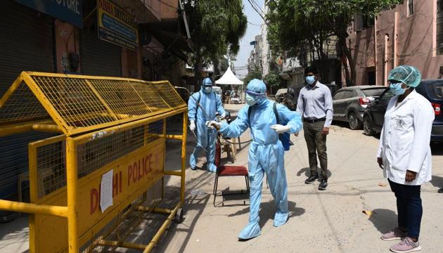 Health workers in Personal Protective Equipment (PPE) kit spray disinfectant to sanitize homes in Bengali Colony (Gali No. 5 and 5A H2 Block) at Mahavir Enclave, a coronavirus containment zone in New Delhi, India, on Thursday, April 16, 2020. (Vipin Kumar/HT PHOTO) Health workers in Personal Protective Equipment (PPE) kit spray disinfectant to sanitize homes in Bengali Colony (Gali No. 5 and 5A H2 Block) at Mahavir Enclave, a coronavirus containment zone in New Delhi, India, on Thursday, April 16, 2020. (Vipin Kumar/HT PHOTO)