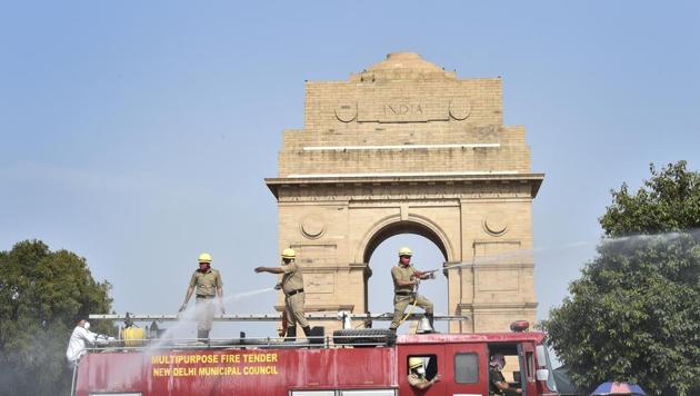 New Delhi Municipal Council (NDMC) health department workers spray disinfectant from a fire tender near India Gate during the lockdown against coronavirus in New Delhi.(Ajay Aggarwal/HT PHOTO)