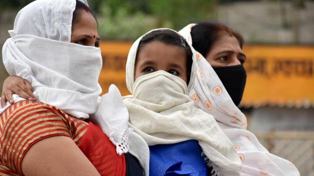 A woman covers face of herself and her child during the second phase of nationwide COVID-19 lockdown in Jabalpur on Wednesday. (ANI photo) A woman covers face of herself and her child during the second phase of nationwide COVID-19 lockdown in Jabalpur on Wednesday. (ANI photo)