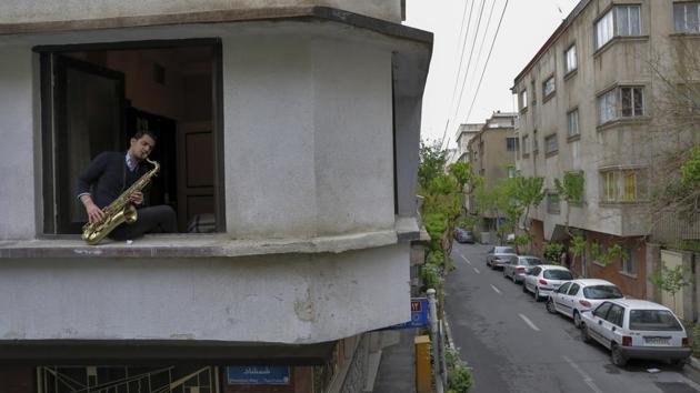 Mohammad Maleklee, 23, of the National Orchestra of Iran and Tehran Symphony, plays the saxophone on his window in Tehran, Iran. (Ebrahim Noroozi / AP) Mohammad Maleklee, 23, of the National Orchestra of Iran and Tehran Symphony, plays the saxophone on his window in Tehran, Iran. (Ebrahim Noroozi / AP)