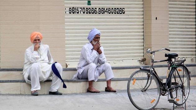 Two men sitting outside a shuttered shop in Kumbra village amid a curfew in Mohali on Friday. (Gurminder Singh/Hindustan Times) Two men sitting outside a shuttered shop in Kumbra village amid a curfew in Mohali on Friday. (Gurminder Singh/Hindustan Times)