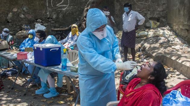 A doctor takes a swab sample of a resident at a COVID-19 coronavirus testing drive inside the Dharavi slums during a government-imposed nationwide lockdown as a preventive measure against the spread of the COVID-19 coronavirus in Mumbai, India, on Thursday, April 16, 2020. (Pratik Chorge/HT Photo)