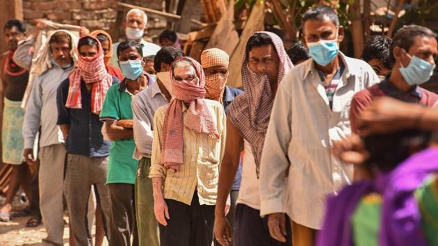 People in a queue at a food distribution by NGO workers during the lockdown against coronavirus, at Kirti Nagar Furniture Market in New Delhi.(Sanchit Khanna/HT PHOTO)