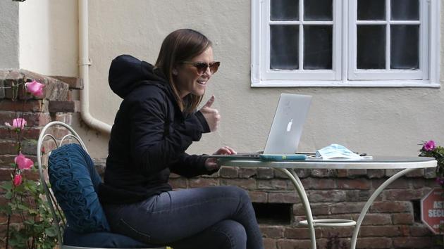 A 3rd grade teacher at Phoebe Hearst Elementary School, gives a thumbs-up during her first online meeting with students and parents on the front lawn of her home in Sacramento, Calif. Monday was the first day of the Sacramento Unified School District's "Distance Learning" program. (AP) A 3rd grade teacher at Phoebe Hearst Elementary School, gives a thumbs-up during her first online meeting with students and parents on the front lawn of her home in Sacramento, Calif. Monday was the first day of the Sacramento Unified School District's "Distance Learning" program. (AP)