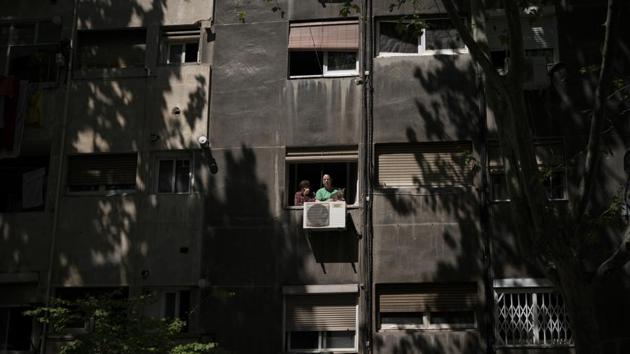 Residents watch from their window as funeral home workers pick up the body of a suspected COVID-19 victim from the nursing home across the street in Barcelona. The virus has killed over 20,000 people in Spain. But funeral homes feel the number is likely much higher. Fernandez says he’s seeing five times more bodies come in than normal. (Felipe Dana / AP) Residents watch from their window as funeral home workers pick up the body of a suspected COVID-19 victim from the nursing home across the street in Barcelona. The virus has killed over 20,000 people in Spain. But funeral homes feel the number is likely much higher. Fernandez says he’s seeing five times more bodies come in than normal. (Felipe Dana / AP)