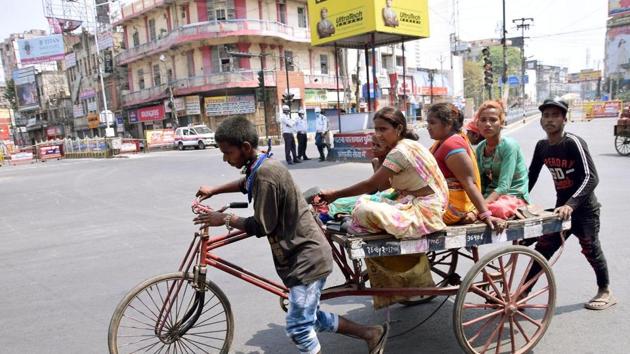 A family travelling on a rickshaw cart at Dak Bungalow crossing during lockdown against coronavirus, in Patna. (Santosh Kumar/ Hindustan Times) A family travelling on a rickshaw cart at Dak Bungalow crossing during lockdown against coronavirus, in Patna. (Santosh Kumar/ Hindustan Times)