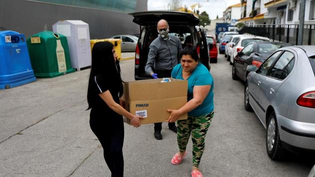 Women carry a box of food donations in Ronda, southern Spain. (REUTERS)