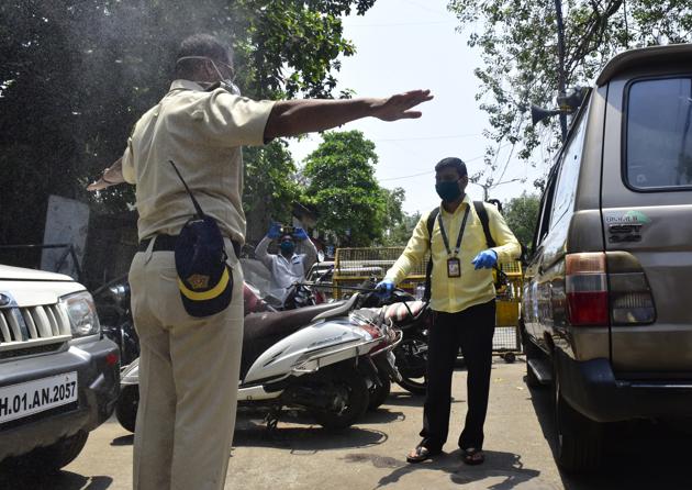 Coronavirus: Police personnel and Volunteer of Mahim Sundal Pathak sprays disinfectant on their colleague of Dharavi Police station, following Covid-19 pandemic at Dharavi in Mumbai.(Anshuman Poyrekar/HT Photo)