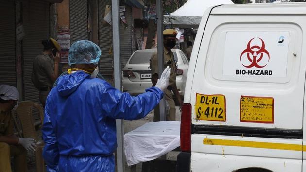 A health worker in Personal Protective Equipment (PPE) kit during garbage collection from homes in Bengali Colony at Mahavir Enclave, a coronavirus containment zone in New Delhi, India, on Thursday, April 16, 2020. (Vipin Kumar/HT PHOTO)