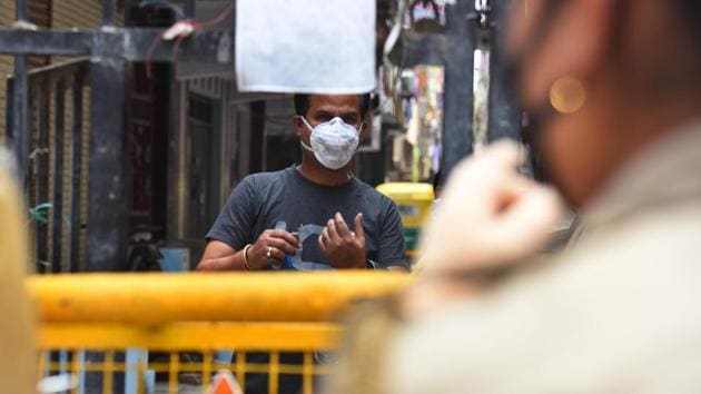 A resident speaks with police personnel standing guard near barricades marking the Pandav Nagar containment zone after it was sealed by Delhi government to curb the spread of coronavirus in New Delhi, India, on Saturday, April 18, 2020. (Raj K Raj/HT PHOTO) A resident speaks with police personnel standing guard near barricades marking the Pandav Nagar containment zone after it was sealed by Delhi government to curb the spread of coronavirus in New Delhi, India, on Saturday, April 18, 2020. (Raj K Raj/HT PHOTO)