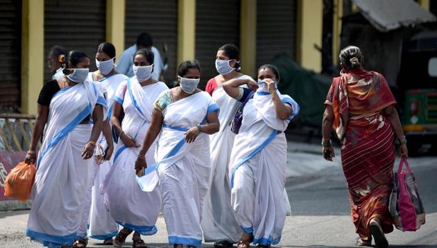 Asha workers cover their face as they cross a road during the nationwide Covid-19 lockdown in Vijayawada on Tuesday.(ANI photo)