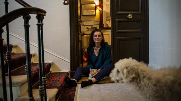 Isabelle plays with her dog and rabbit as she sits on the floor by the door of her apartment. Company takes different forms. (Elena Fusco / AFP)
