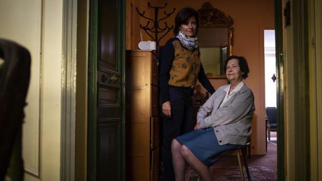 Carole, came from Geneva to be with her mother Marina (R), poses with her at the entrance door of the apartment where they live in Paris.Those who were lucky made it in time before restrictions held them in where they were. (Elena Fusco / AFP)