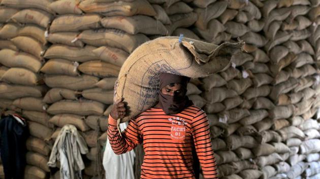 A worker carries a sack containing rice grain to store at a Food Corporation of India (FCI) warehouse in Jammu. Though a large portion of the harvesting process is mechanised, the packing and transportation of wheat involves manual labour. (Nitin Kanotra / HT Photo)