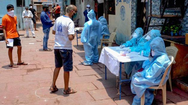 Medics is protective suits conduct a health checkup of residents at a labour camp in Dharavi in Mumbai. (PTI) Medics is protective suits conduct a health checkup of residents at a labour camp in Dharavi in Mumbai. (PTI)