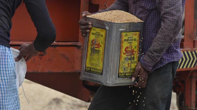 A worker packs wheat with the help of a canister at a market in Naubatpur area of Patna during the lockdown. (Parwaz Khan / HT Photo)