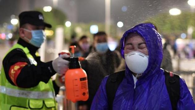 A police officer sprays disinfectant on a traveller outside Hankou Railway Station after travel restrictions to leave Wuhan, the capital of Hubei province and China's epicentre of the novel coronavirus disease ( Covid-19) outbreak, were lifted. (REUTERS) A police officer sprays disinfectant on a traveller outside Hankou Railway Station after travel restrictions to leave Wuhan, the capital of Hubei province and China's epicentre of the novel coronavirus disease ( Covid-19) outbreak, were lifted. (REUTERS)