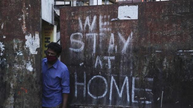A man wearing a face mask looks out from a gate during lockdown to prevent the spread of new coronavirus in Hyderabad, on Saturday.(AP Photo) A man wearing a face mask looks out from a gate during lockdown to prevent the spread of new coronavirus in Hyderabad, on Saturday.(AP Photo)