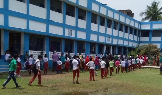 Students in a government-aided school in Murshidabad district in West Bengal stand in queues for rice and potatoes in lieu of their regular mid-day meals on Monday. (Sourced) Students in a government-aided school in Murshidabad district in West Bengal stand in queues for rice and potatoes in lieu of their regular mid-day meals on Monday. (Sourced)