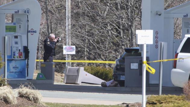 A member of the Royal Canadian Mounted Police (RCMP) forensic identification unit photographs the body of a deceased man after a deadly shooting rampage, at the Big Stop near Elmsdale, Nova Scotia, Canada, on April 19, 2020. (AFP) A member of the Royal Canadian Mounted Police (RCMP) forensic identification unit photographs the body of a deceased man after a deadly shooting rampage, at the Big Stop near Elmsdale, Nova Scotia, Canada, on April 19, 2020. (AFP)