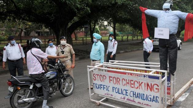 Chandigarh traffic police have mounted a corona 'scarecrow ' on the dividing road of Sector 18-19 amid the lockdown on Monday.(Keshav Singh/HT photo)