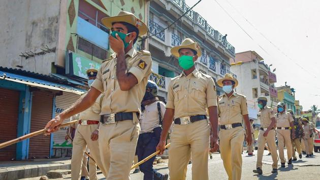 Police personnel conduct a march in areas of Padarayanapura in Chamarajapet during ongoing COVID-19 lockdown, in Bengaluru. (PTI) Police personnel conduct a march in areas of Padarayanapura in Chamarajapet during ongoing COVID-19 lockdown, in Bengaluru. (PTI)