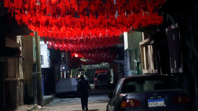 A man walks in front of closed shops and decorations for the Muslim holy month of Ramadan which also know for Egyptians as "zeinat Ramadan" during the night-time curfew to contain the spread of the coronavirus disease (COVID-19) in Toukh, Al Qalyubia Governorate, north of Cairo, Egypt.(REUTERS)