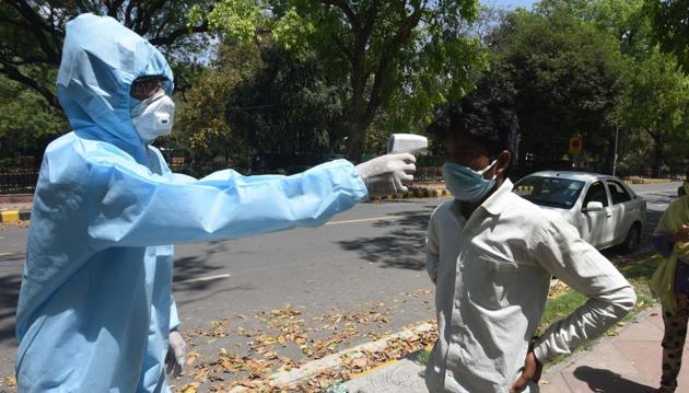 People are thermal screened and sensitized about the coronavirus by a worker in PPE overalls before a food distribution organised by the Indian Youth Congress outside IYC Office at Raisina Road, New Delhi, India on Sunday, April 19, 2020. (Sonu Mehta/HT PHOTO) People are thermal screened and sensitized about the coronavirus by a worker in PPE overalls before a food distribution organised by the Indian Youth Congress outside IYC Office at Raisina Road, New Delhi, India on Sunday, April 19, 2020. (Sonu Mehta/HT PHOTO)