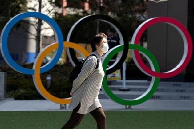 A woman wearing a protective face mask, following an outbreak of the coronavirus disease (COVID-19), walks past the Olympic rings in front of the Japan Olympics Museum in Tokyo.(REUTERS) A woman wearing a protective face mask, following an outbreak of the coronavirus disease (COVID-19), walks past the Olympic rings in front of the Japan Olympics Museum in Tokyo.(REUTERS)