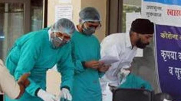 Doctors and medical workers in protective face masks and hairnets at a COVID-19 help desk, on day twenty of the national lockdown to curb the spread of coronavirus, at Civil Hospital Sector 10, in Gurugram, India, on April 13, 2020. (Yogendra Kumar/HT PHOTO) Doctors and medical workers in protective face masks and hairnets at a COVID-19 help desk, on day twenty of the national lockdown to curb the spread of coronavirus, at Civil Hospital Sector 10, in Gurugram, India, on April 13, 2020. (Yogendra Kumar/HT PHOTO)