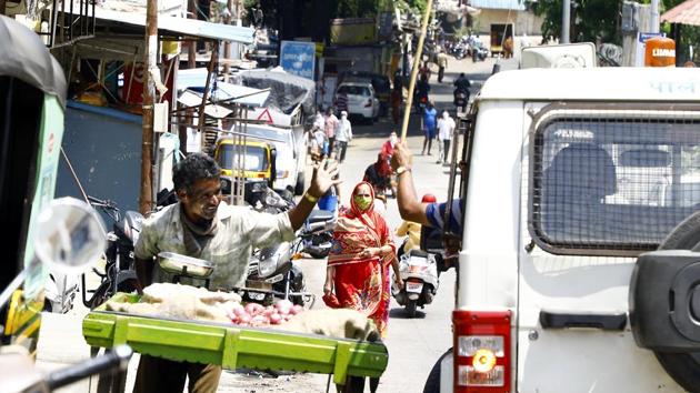 A police official gestures a vegetable vendor with a baton to stop sale at Upper Depot Indiranagar on Sunday. (Rahul Raut/HT) A police official gestures a vegetable vendor with a baton to stop sale at Upper Depot Indiranagar on Sunday. (Rahul Raut/HT)