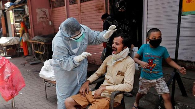 A doctor wearing a hazmat suit and a mask conducts a swab test on a man, to check if he has the coronavirus, in Mumbai’ Dharavi on Monday. (Reuters Hoto) A doctor wearing a hazmat suit and a mask conducts a swab test on a man, to check if he has the coronavirus, in Mumbai’ Dharavi on Monday. (Reuters Hoto)