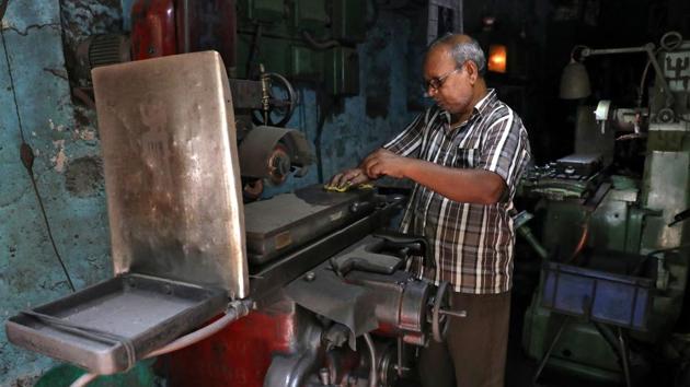 A worker removes dust from a lathe machine inside a workshop which reopened after weeks-long shutdown. (Rupak De Chowdhuri / REUTERS) A worker removes dust from a lathe machine inside a workshop which reopened after weeks-long shutdown. (Rupak De Chowdhuri / REUTERS)