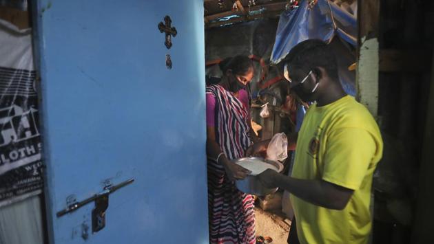 Mina Jakhawadiya receives free ration from her neighbour. “I know we are facing bad days ahead,” said Jakhawadiya, a 47-year-old woman who, like many in India’s vast slums, is a force of will. She knew how to arrange for a daughter’s heart surgery and can feed her family on her minuscule profits. But she’s never faced anything like this. (Rafiq Maqbool / AP)