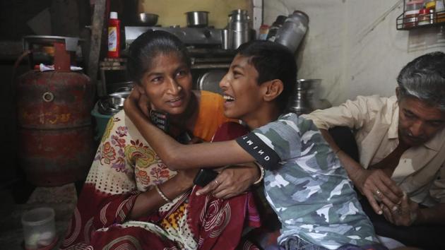 Mina Jakhawadiya, shares light moment with her son Ritik Ramesh in her house. “I saw him (Ramesh) laughing today,” Mina said one day, surprised. “The kids were laughing too. I felt really good inside but I have this perpetual fear of what might happen next. Today we have a roof to sleep under, but what if tomorrow we’re evicted? What if we have no food?” (Rafiq Maqbool / AP)