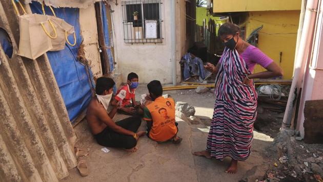 Mina Jakhawadiya scolds her son Ritik Ramesh, (in red) to not play outside during lockdown. She refuses to watch the news anymore. “There is no good news right now,” she said. “All they talk about on the television is people dying.” (Rafiq Maqbool / AP)