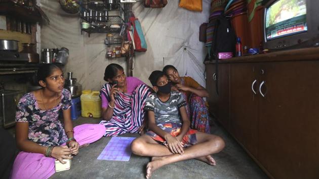 Mina Jakhawadiya (C), watches news on coronavirus with her children in her one room house in a slum in Mumbai during lockdown. Jakhawadiya and her family of five had crowded arounded their TV set much the same way on March 24, when Prime Minster Narendra Modi announced, “Every state, every district, every lane, every village will be under lockdown” for three weeks. (Rafiq Maqbool / AP)