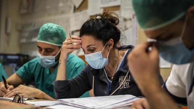 Settembrese is seen with her colleagues during the night meeting at the end of her work shift. Before she leaves work for the night, she reviews with her colleagues how the patients are faring. Not just how well they are breathing but whether they feel angry or distraught because relatives have died from COVID-19. (Luca Bruno / AP) Settembrese is seen with her colleagues during the night meeting at the end of her work shift. Before she leaves work for the night, she reviews with her colleagues how the patients are faring. Not just how well they are breathing but whether they feel angry or distraught because relatives have died from COVID-19. (Luca Bruno / AP)