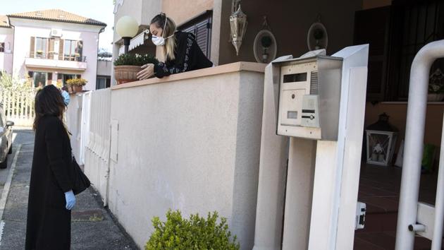 Cristina Settembresse chats with Rebecca, who leans over a first-floor balcony, whenever Settembrese can pass by. A single parent, her only companion now in her apartment is her Chihuahua, Pepe, who gets bundled in a faux leopard-skin coat for a walk. (Luca Bruno / AP) Cristina Settembresse chats with Rebecca, who leans over a first-floor balcony, whenever Settembrese can pass by. A single parent, her only companion now in her apartment is her Chihuahua, Pepe, who gets bundled in a faux leopard-skin coat for a walk. (Luca Bruno / AP)
